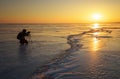 Photographer take pictures on the ice at sunset