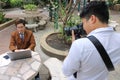 Photographer takes a photo of portrait of handsome young business man while using laptop. Royalty Free Stock Photo