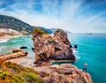 Photographer takes picture of huge cliff and Pelekas beach on background. Exciting morning seascape of Ionian Sea, Corfu island, K