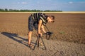 Photographer takes pictures ground textures in hot day. Royalty Free Stock Photo