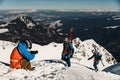 photographer takes pictures of male skiers with ski equipment climbing a snowy slope