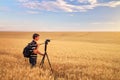 Photographer takes pictures in a wheat field. Royalty Free Stock Photo