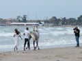 Photographer takes pictures of a young couple with a horse on the Mediterranean coast near the city Ako in Israel