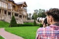 Photographer taking photo of beautiful house with camera outdoors Royalty Free Stock Photo