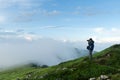 Photographer taking photo of cloudy mountains