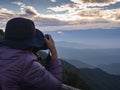 Photographer taking photo of landscape from top of the mountain