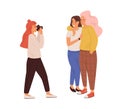 Photographer taking photo of lesbian love couple. Young woman with camera shooting portrait of smiling female friends