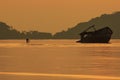 Photographer taking a photo of old wreck boat against sun rising Royalty Free Stock Photo