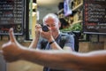 Photographer taking photos of lively streets with restaurants Royalty Free Stock Photo