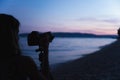 Photographer taking photos of sea and shore at dusk Royalty Free Stock Photo