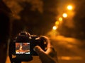 Photographer taking photos with tripot at night. street photography with tripod on the street Royalty Free Stock Photo