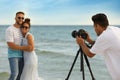 Photographer taking picture of couple with professional camera near sea Royalty Free Stock Photo