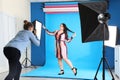 Photographer taking picture of woman in studio. Plus size model Royalty Free Stock Photo