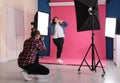 Photographer taking picture of woman in studio. Plus size model Royalty Free Stock Photo