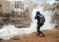 Photographer taking picture of a stormy sea in Polignano a Mare, Italy