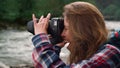 Photographer taking pictures of nature. Excited woman using photo camera outdoor Royalty Free Stock Photo