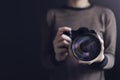 Photographer Taking Self-Portrait. Woman using Camera to Taking Photo. Dark Tone, Front View. Selective focus on Lense. Straight