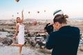 Photographer is taking shot of a woman at the background with Hot Air Balloons in Cappadocia Royalty Free Stock Photo