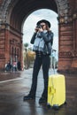 Photographer tourist with retro photo camera. Girl in hat travels in Triumphal arch Barcelona. Holiday concept in europe city Royalty Free Stock Photo