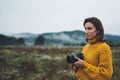 Photographer tourist take photo on camera lens on background autumn foggy mountain, traveler hipster shooting video nature mist