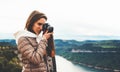Photographer tourist traveler standing on green top on mountain holding in hands digital photo camera, hiker taking click photogra Royalty Free Stock Photo