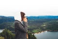 Photographer tourist traveler standing on green top on mountain holding in hands digital photo camera, hiker taking click photo Royalty Free Stock Photo