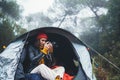Photographer tourist traveler take photo on camera in camp tent in froggy rain forest, hiker woman shooting mist nature trip Royalty Free Stock Photo