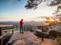 Photographer on tourist view platform takes pictures with big DSLR camera i