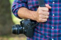 Photographer or traveler concept. Photographer holding digital camera in his hands Royalty Free Stock Photo