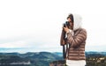 Photographer traveler on green top on mountain, tourist looking holding in hands digital photo camera, hiker taking click photo Royalty Free Stock Photo