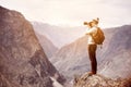 Photographer or traveller on big rock against mountains Royalty Free Stock Photo