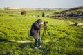 A photographer or traveller using a professional DSLR camera on a tripod in the nature for background. Royalty Free Stock Photo