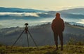 Photographer, Tripod Camera and Morning Panorama of the Carpathian Mountains