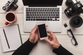 Photographer using smartphone on workplace