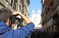 photographer in Via dei Condotti in Rome Italy and the church of