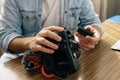 A photographer or videographer changing the battery of his camera. The camera has an external microphone for vlogs and videos on Royalty Free Stock Photo