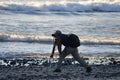 Photographer at water`s edge on Coastal Beach