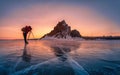 Photographer wear red clothes take photo of Shamanka rock at sunrise with natural breaking ice in frozen water on Lake Baikal, Royalty Free Stock Photo