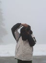 Photographer in the winter snow doing nature shots and capturing wildlife
