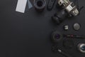 Photographer workplace with dslr camera system, camera cleaning kit, lens and camera accessory on dark black table background
