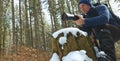 Photographer. young man with tele photo camera in forest.