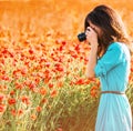 Woman taking photographs the poppies meadow. Royalty Free Stock Photo