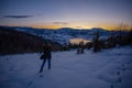 Photographers photographing winter lake mountain scene in sunset, alone in wilderness