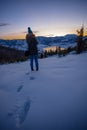 Photographers photographing winter lake mountain scene in sunset, alone in wilderness