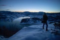 Photographers photographing winter lake mountain scene in sunset, alone in wilderness