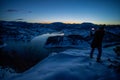 Photographers photographing winter lake mountain scene in sunset, alone in wilderness