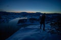 Photographers photographing winter lake mountain scene in sunset, alone in wilderness