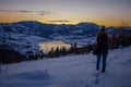 Photographers photographing winter lake mountain scene in sunset, alone in wilderness