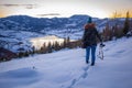 Photographers photographing winter lake mountain scene in sunset, alone in wilderness