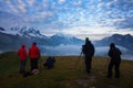 Photographers stay on lake and takes photos. Dreamy mountains, orange sunrise in a beautiful valley. Colorful summer